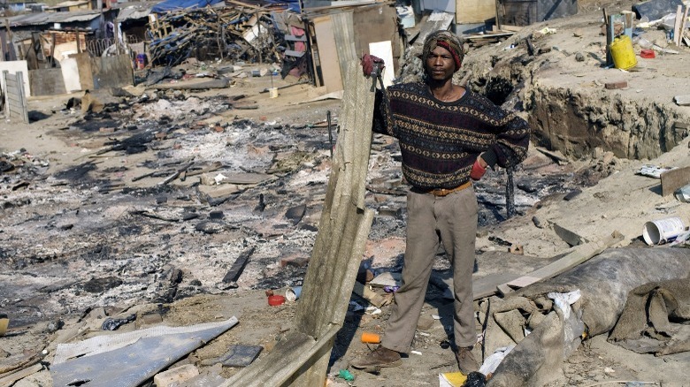 Rasta standing amid rubble
