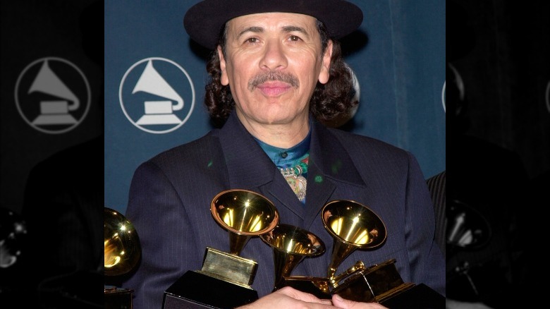 Carlos Santana holding Grammys