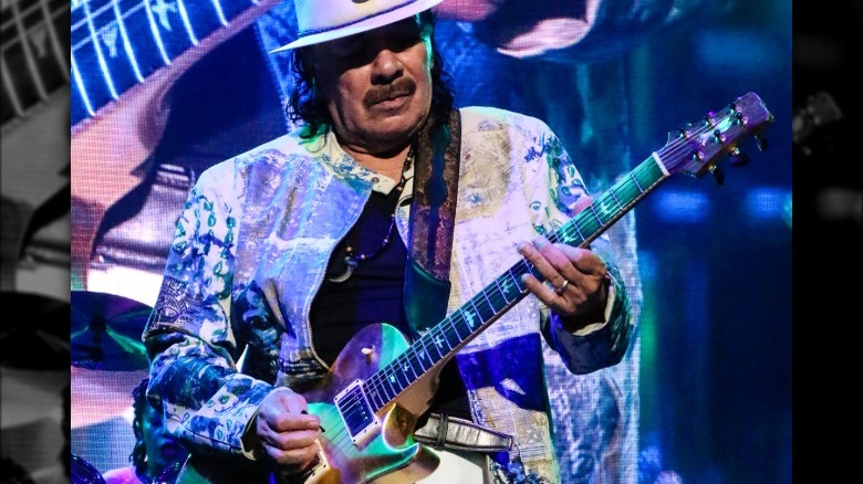 Carlos Santana playing guitar onstage 