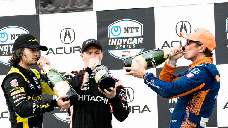 Scott Dixon (right) and his fellow drivers enjoying champagne