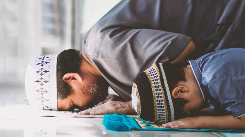 A Muslim man and his son praying