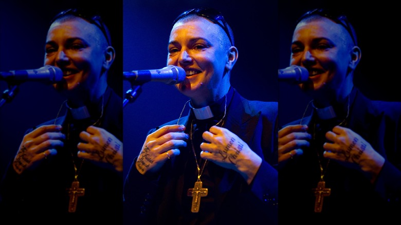 Sinéad O'Connor onstage as priest smiling