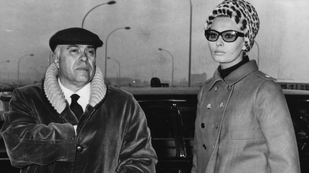 Carlo Ponti and Sophia Loren in outerwear, outside