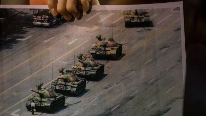 A  protester carrying a photo of Tank Man