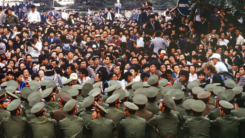 Democracy protesters face a group of soldiers in Tiananmen