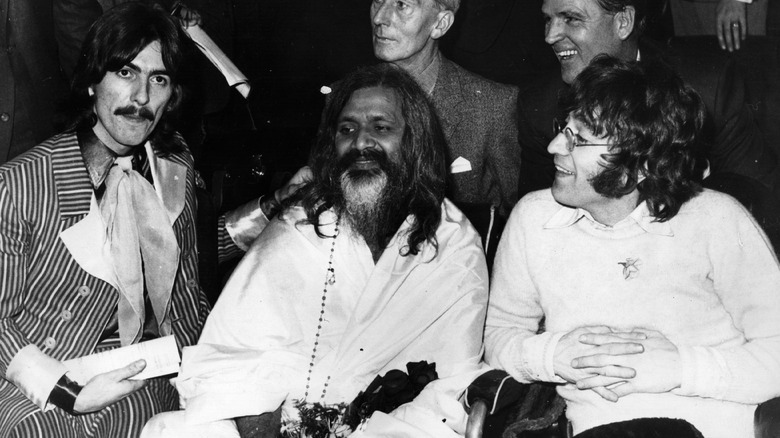 Maharishi Mahesh Yogi seated with George Harrison and John Lennon