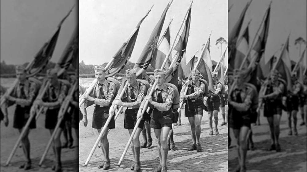 Hitler Youth members in formation holding flags