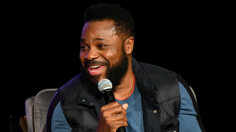 Malcolm Jamal Warner smiling talking into a microphone