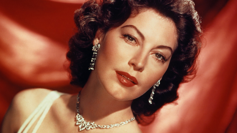 Ava Gardner in dress in front of red curtain