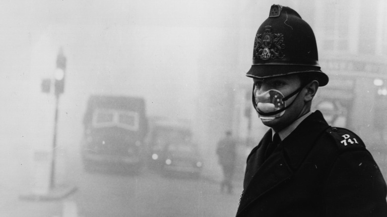 A policeman masks up against a pea-soup smog
