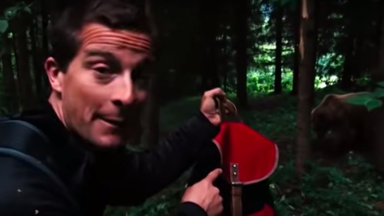 Bear Grylls with a backpack and grizzly bear