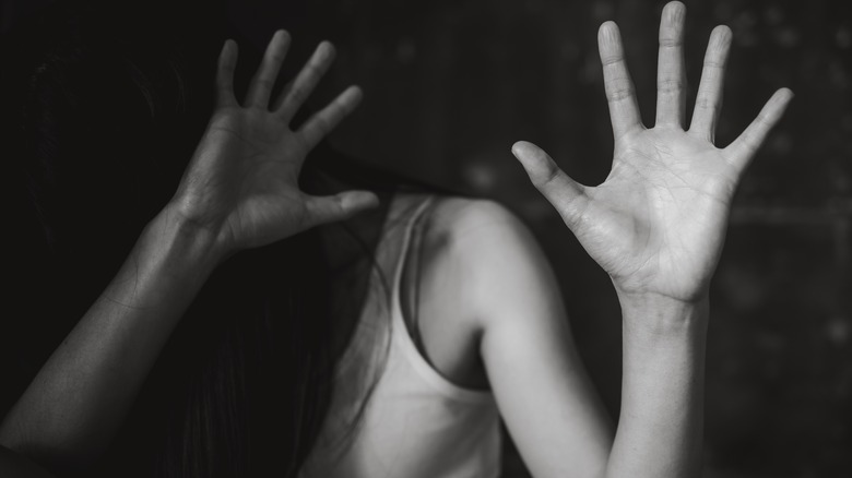 A woman putting her hands up in a defensive posture