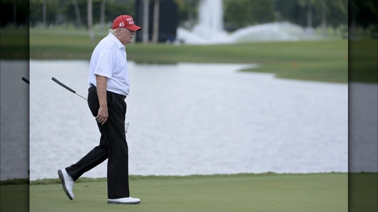 Trump on golf course with MAGA hat
