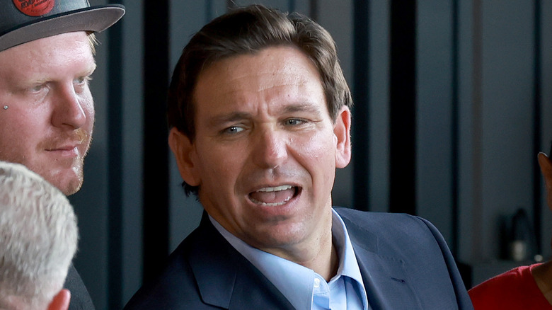 Ron DeSantis grimacing while talking with supporters 