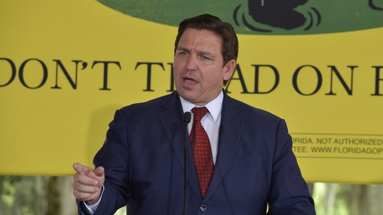 Ron DeSantis speaking in front of Don't Tread on Me flag