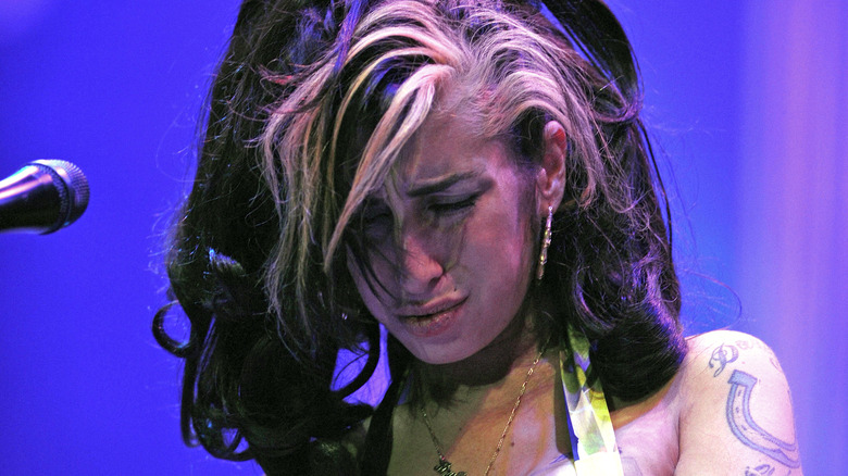 Amy Winehouse on stage looking sad 
