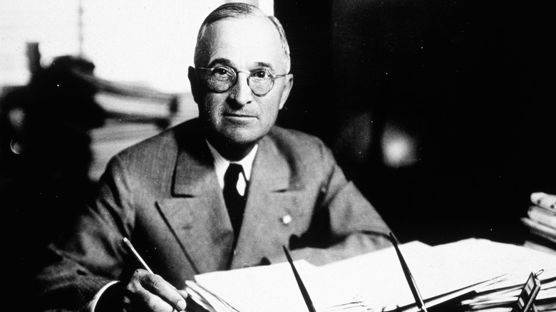 Truman suit sitting at desk