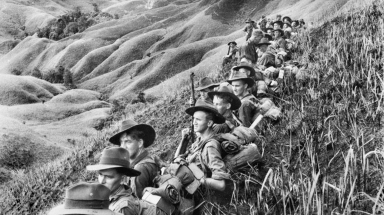Australian armed soldiers sat on hill