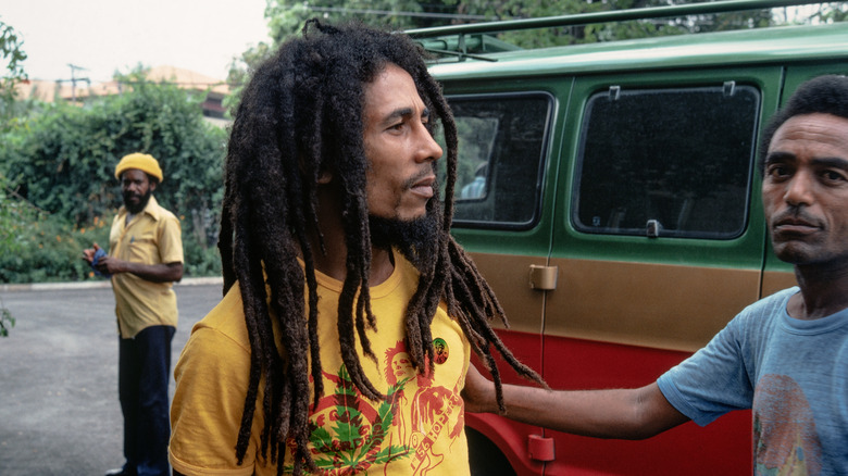 Bob Marley yellow shirt in front of a van