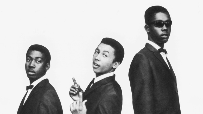 The Wailers posing in tuxedos white background