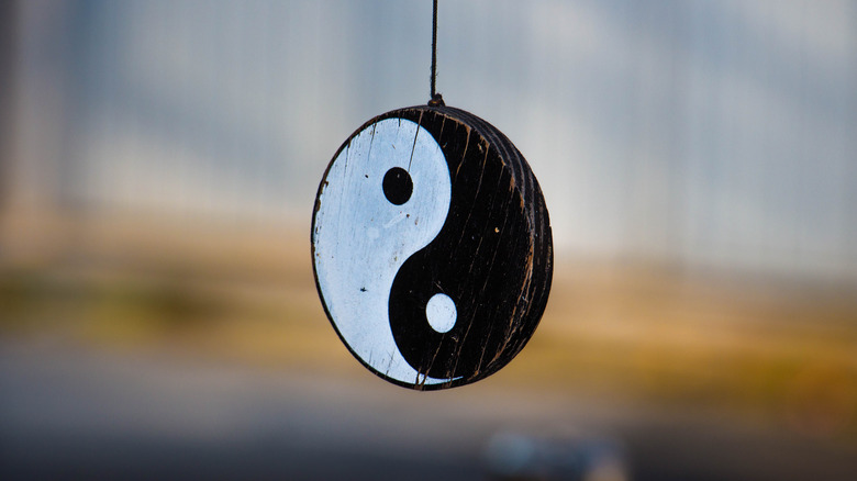 yin and yang symbol hanging on string