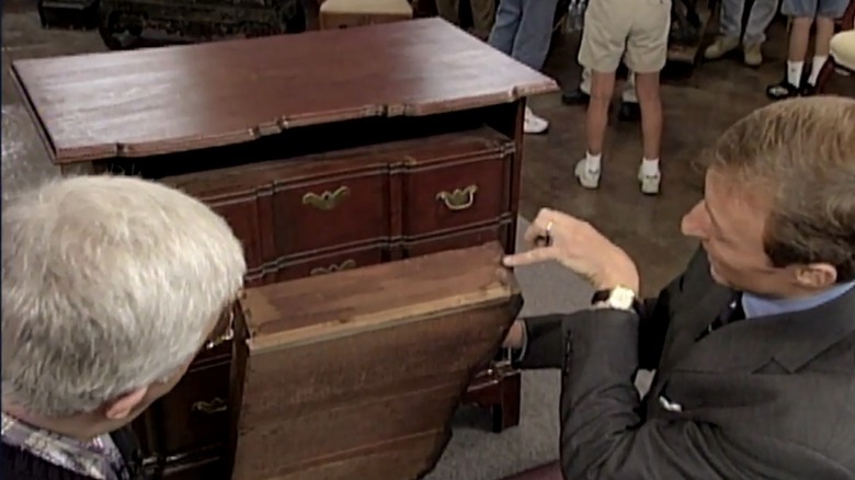 appraiser examines furniture drawer