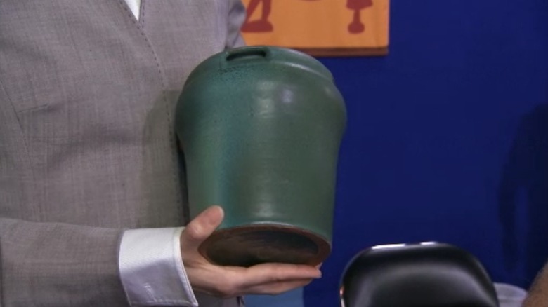 hands hold green ceramic vase