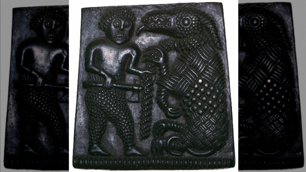 Bronze plaque showing a Viking holding a chained bear