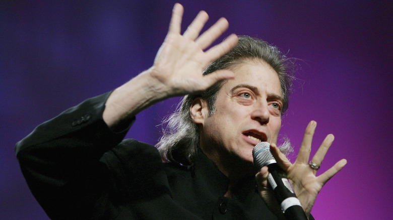 Richard Lewis on stage with hands raised