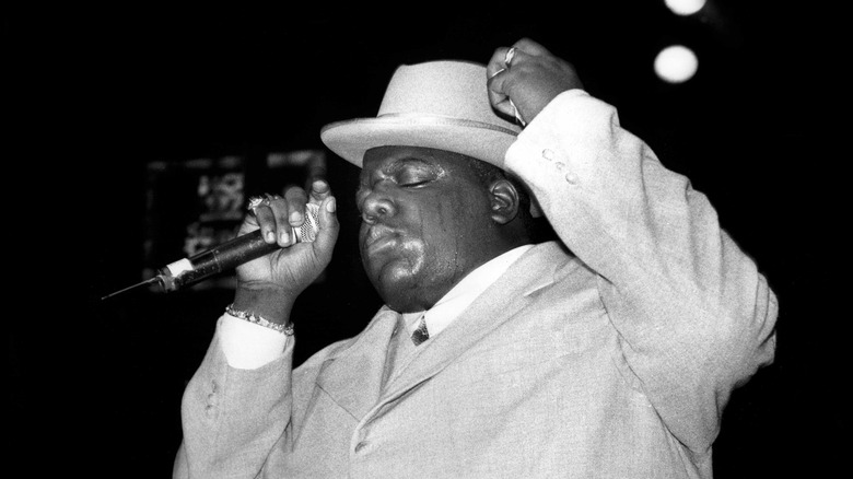 Notorious B.I.G on stage in suit and hat