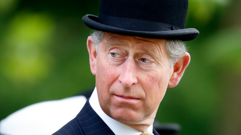 Prince Charles looks over his shoulder bowler hat