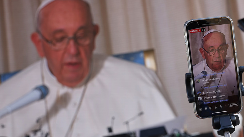 pope francis being filmed at a news conference