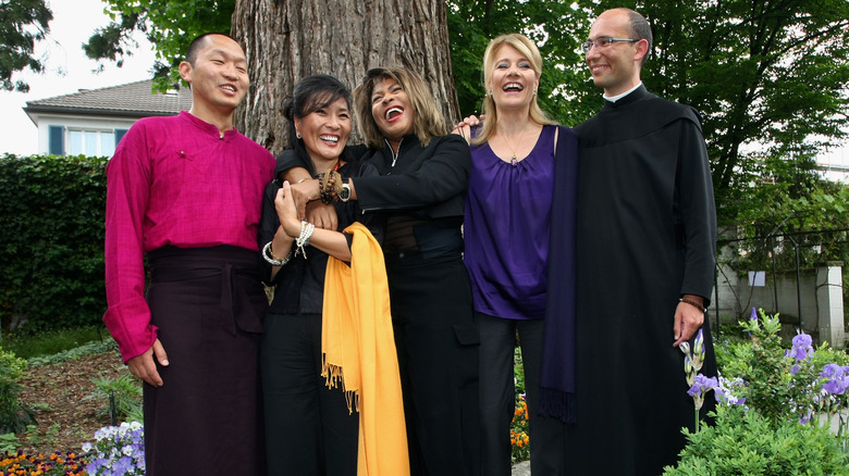 Tina Turner laughing outside with other Buddhists 