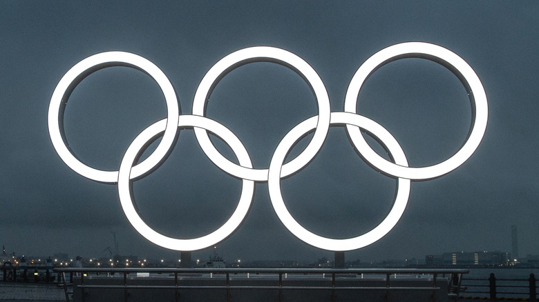 Olympic rings with city behind