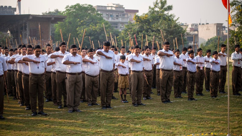 RSS men salute with sticks