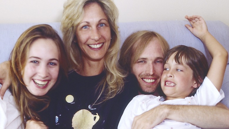 Tom Petty with wife and two young daughters smiling