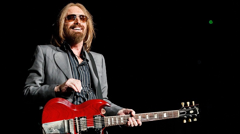 Tom Petty smiling and holding red guitar