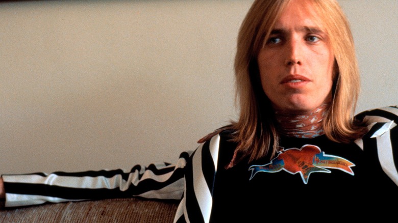 Tom Petty sat on sofa black and white striped sweater