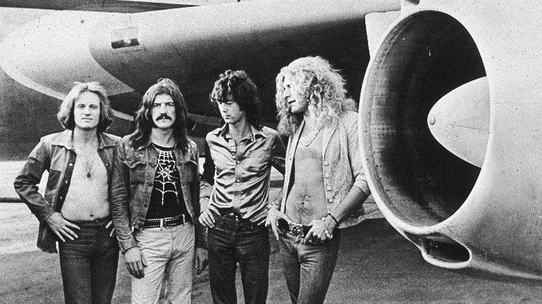 Led Zeppelin standing in front of their jet
