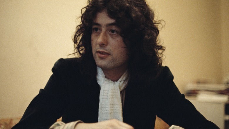 Jimmy Page looking to side white scarf black jacket