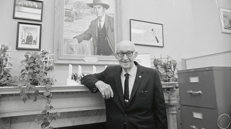 Carl Hayden leaning on a fireplace mantle