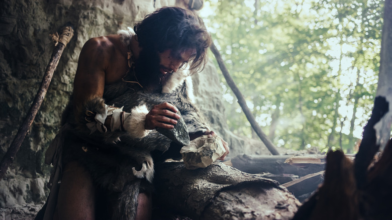 prehistoric person making tools