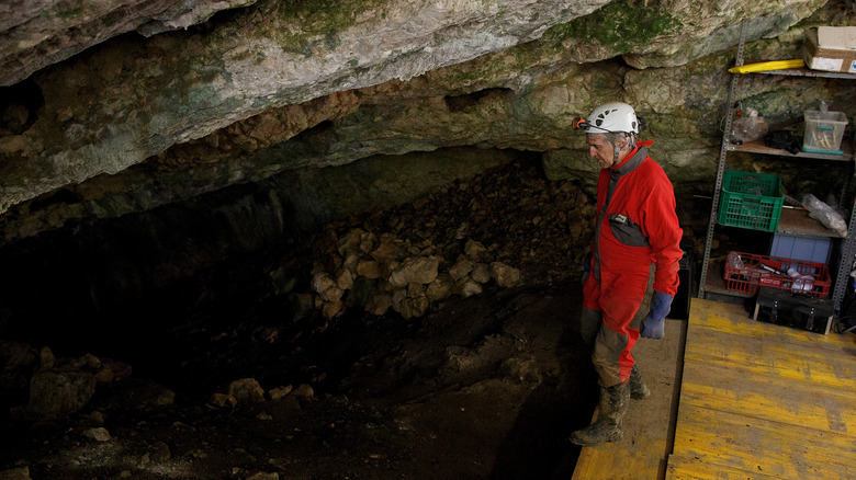 man in red suit excavating cave
