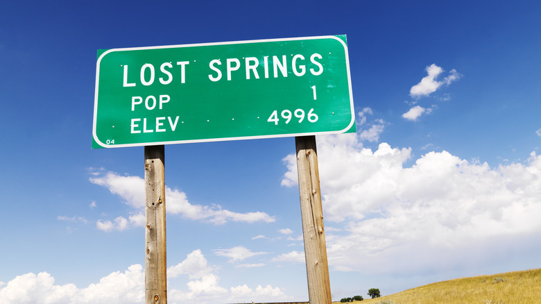 Green elevation sign for Lost Springs by field
