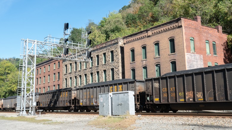 Old red brick warehouses by rail cars tall trees
