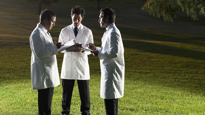 scientists white labcoats on field