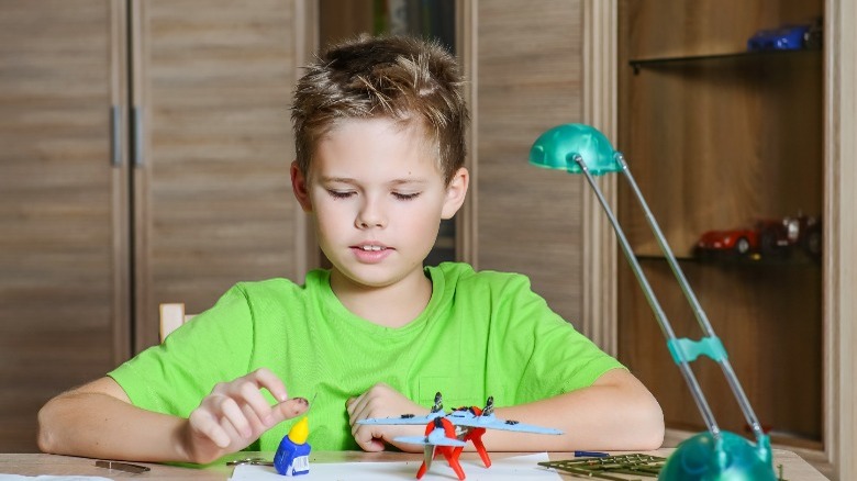 boy assembling a model plane