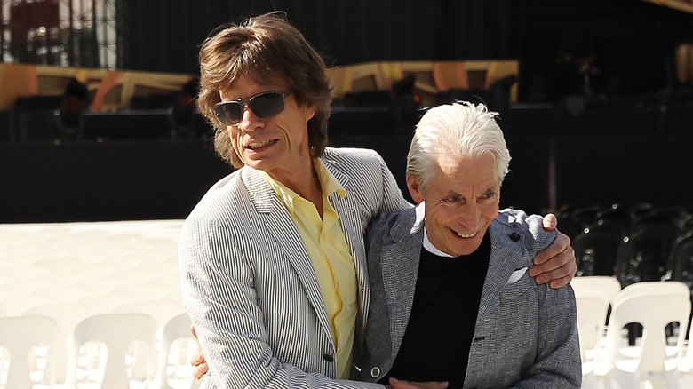 Mick Jagger hugs Charlie Watts
