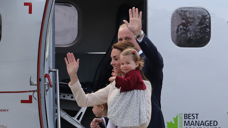 The Cambridges wave as they board a plane