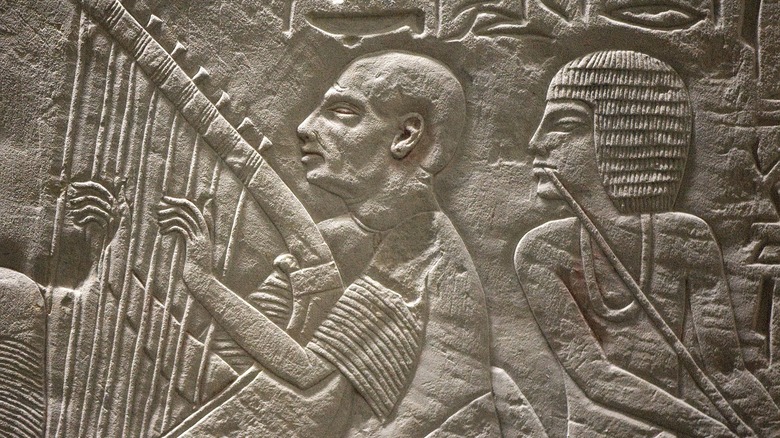 Ancient Egypt harpist playing in a tomb relief